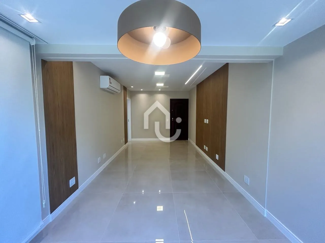 Sala de estar ampla e iluminada de apartamento na Barra da Tijuca.